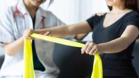 Doctor helping patient do arm and shoulder physiotherapy.